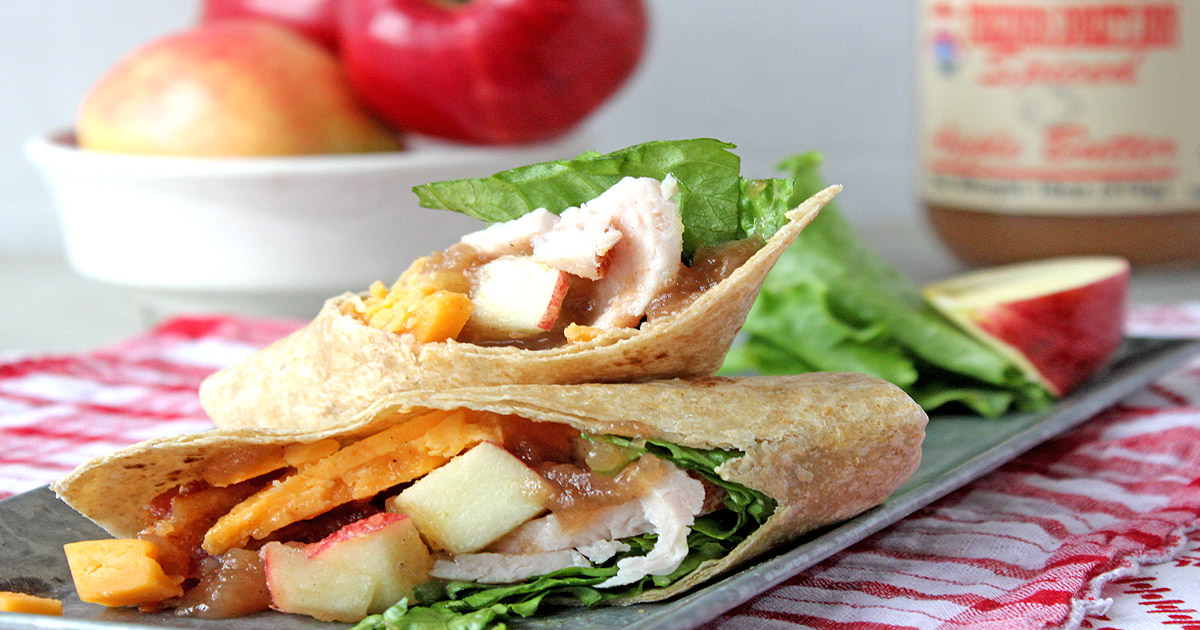 Turkey wrap with fresh apples and jar of apple butter in background