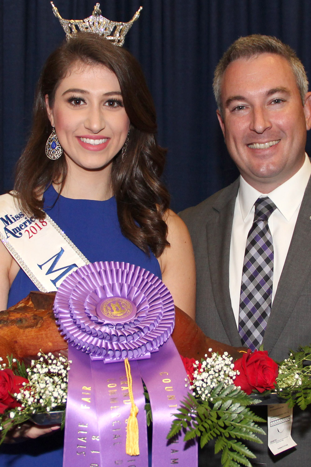 Miss Kentucky with Kentucky Agricultural Commisioner Ryan Quarles holding an award-winning country ham at the Kentucky State Fair.