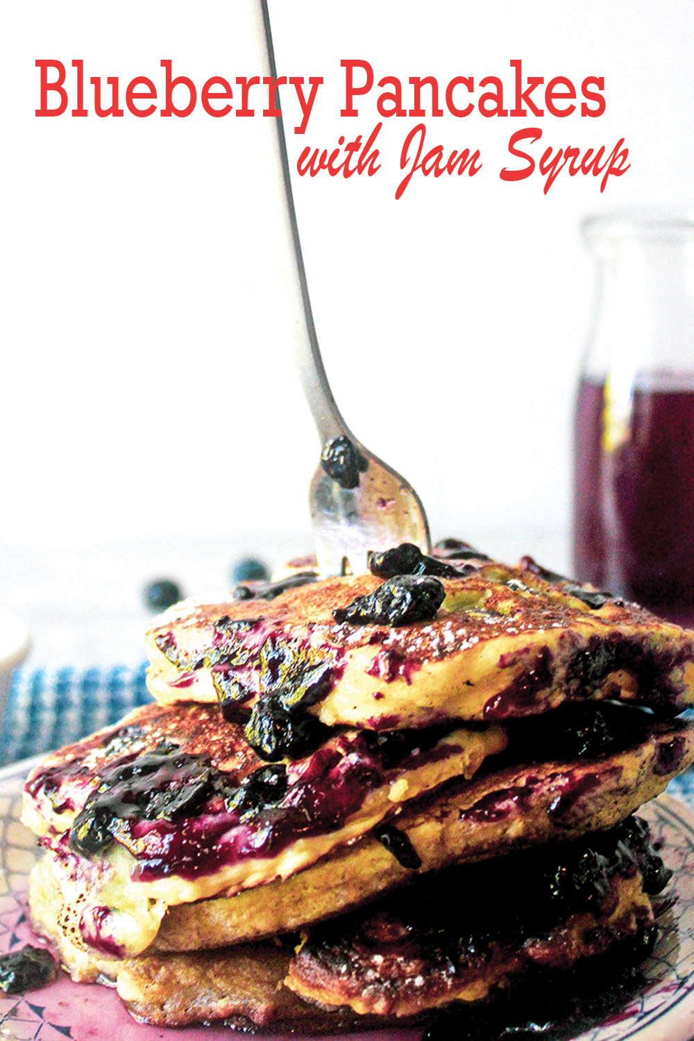 Stack of fluffy blueberry pancakes with a fork stuck in top