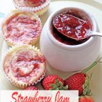 Overhead view of individual strawberry jam swirled cheesecakes with jam pot
