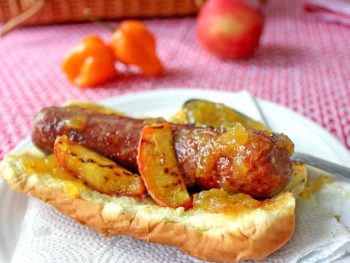 Grilled hot dog on bun with peach habanero jam glaze