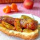 Grilled hot dog on bun with peach habanero jam glaze
