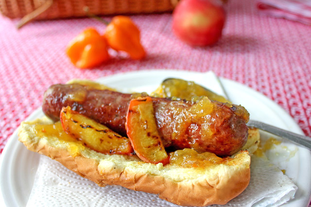 Grilled hot dog on bun with peach habanero jam glaze