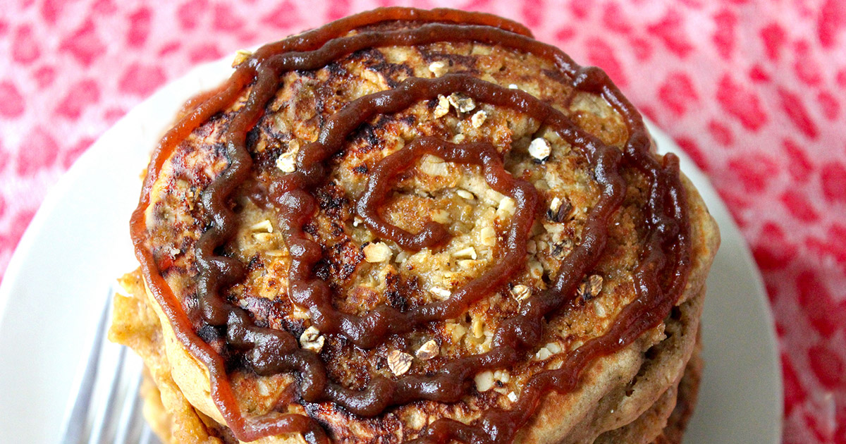 Spiced apple butter pancakes stack with a spiral swirl of apple butter atop the struesel