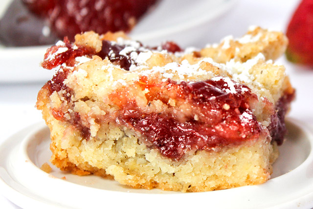 Strawberry jam bar on a white plate with a sprinkle of confectionary sugar