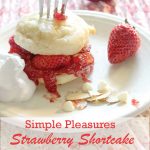 Strawberry Shortcake Biscuit Scone with fork stuck in it, stuffed with berries, jam and a side of whipped cream.