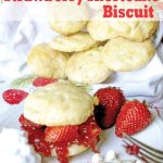Strawberry shortcake biscuit scone dripping with jam and berries and a scattering of biscuits in the background.