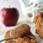 Slice of apple butter bread with fresh apple and teapot in background.
