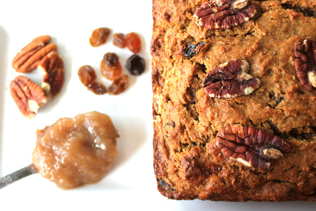 Loaf apple butter bread with spoon of apple butter, strewn pecans and raisins