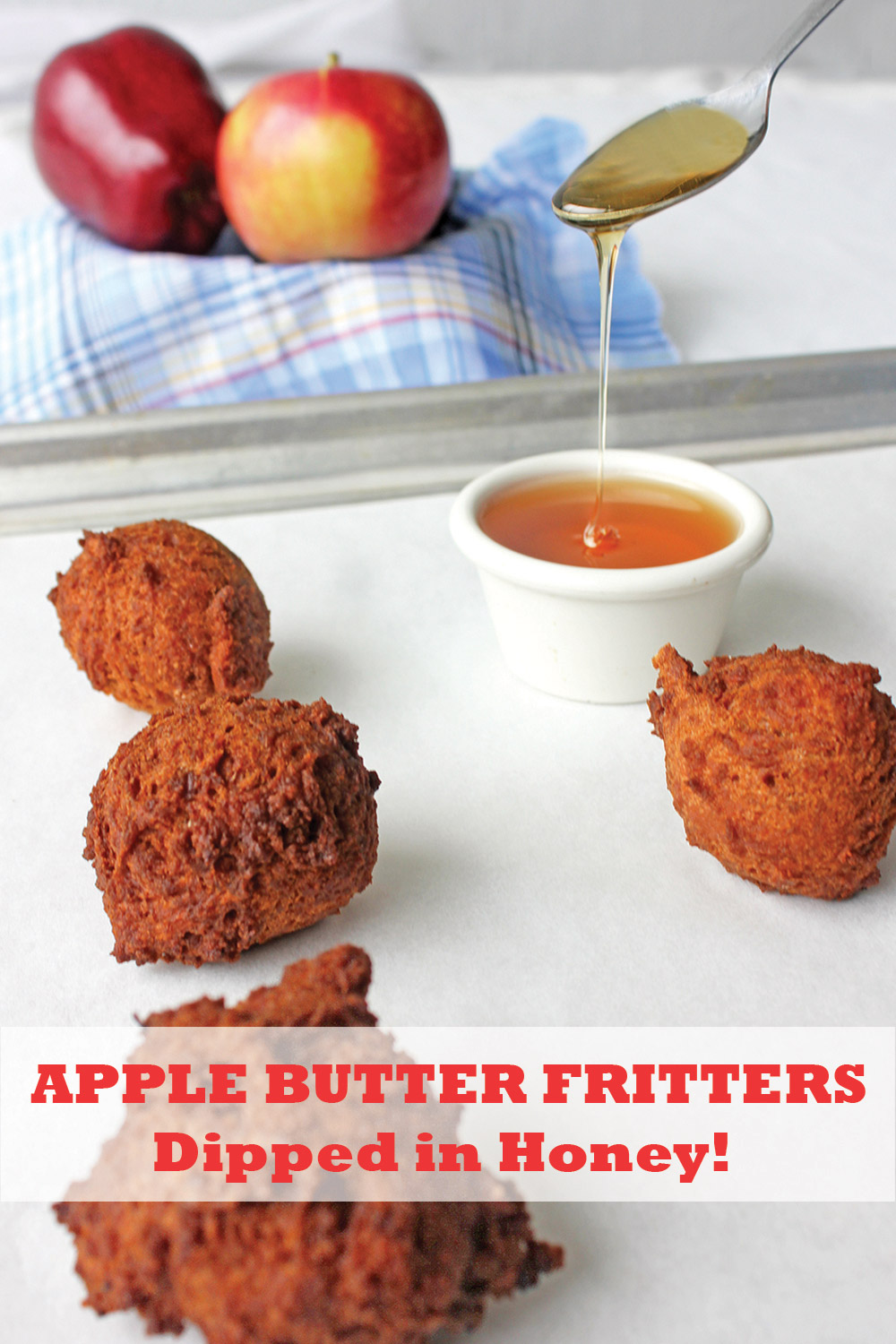 Apple Butter Fritters on a baking tray with honey on teaspoon