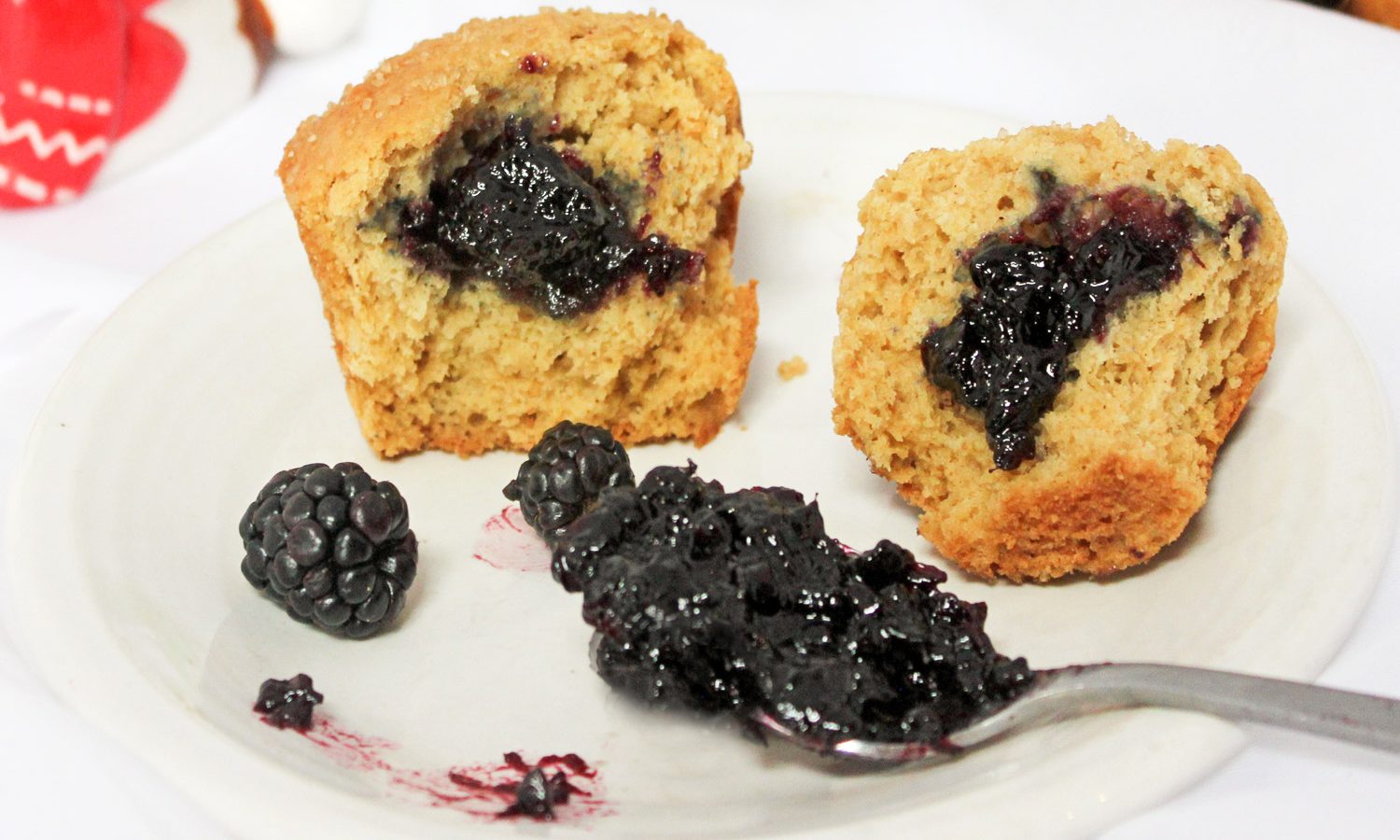 Blackberry jam on spoons with blackberry jam filled muffins