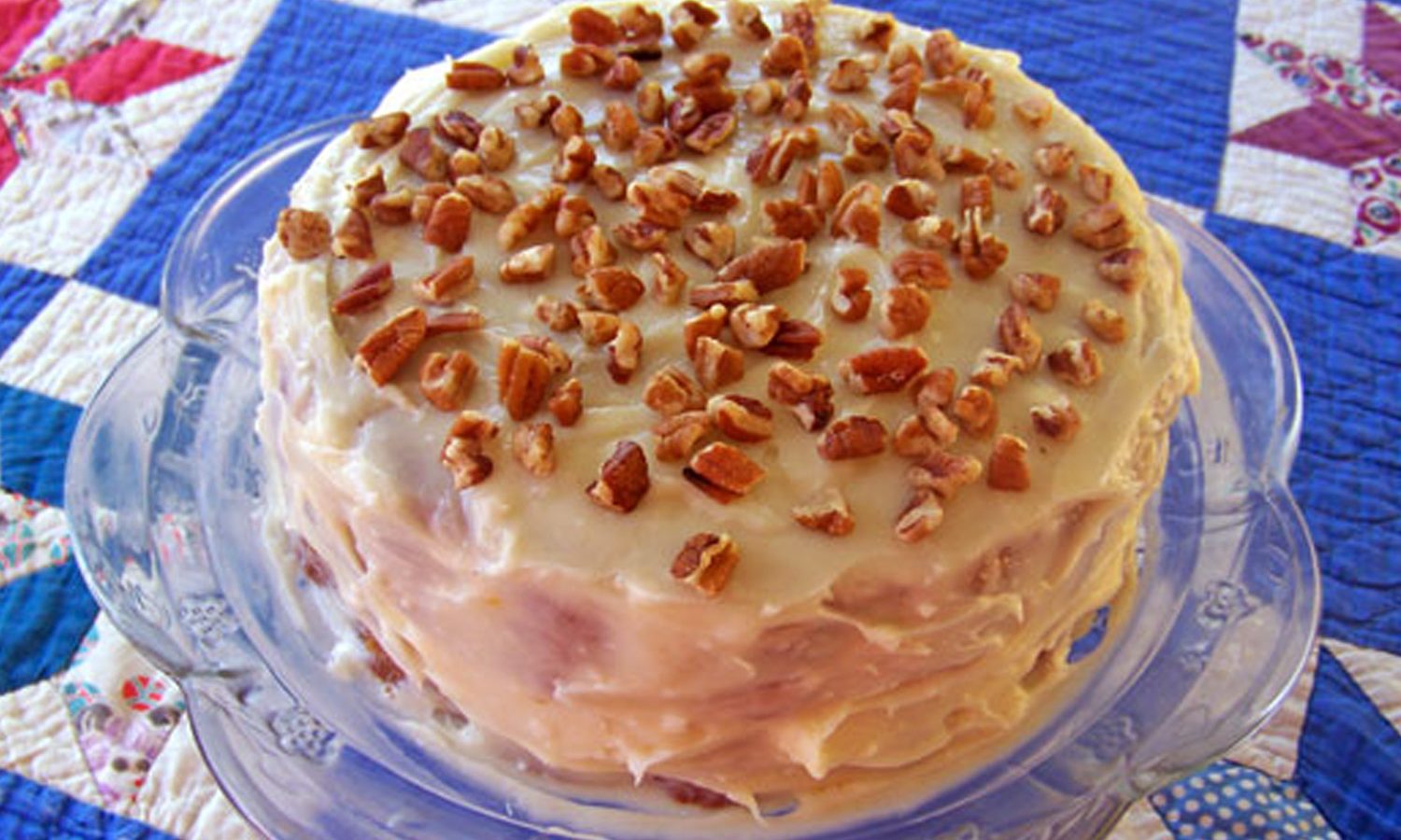 Pawpaw cake with frosting and nuts on top of a blue quilt