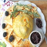 View from above, baked brie berries with jam plated with fresh blackberries, blackberry jam and rosemary.