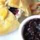 Baked brie berries with jam oozing from puff pastry.