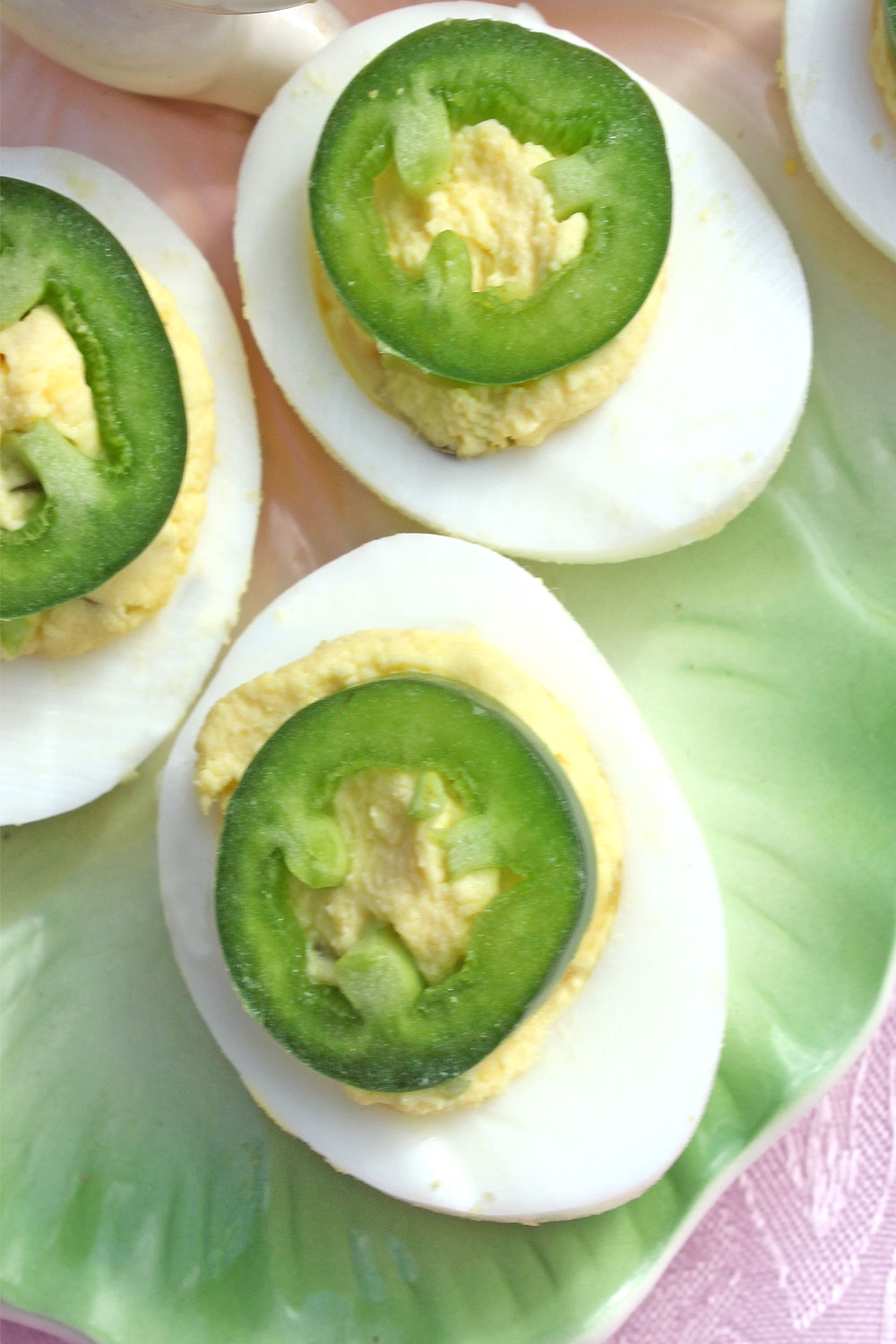 Overhead view of deviled eggs garnished with jalapeno pepper rings